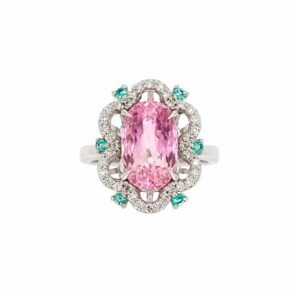 Ring with a large oval pink center stone surrounded by diamonds and teal accent stones on a silver band.