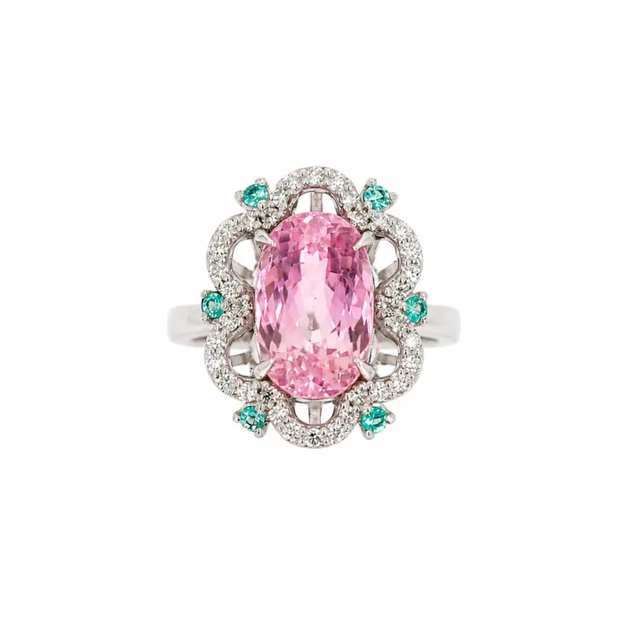 Ring with a large oval pink center stone surrounded by diamonds and teal accent stones on a silver band.