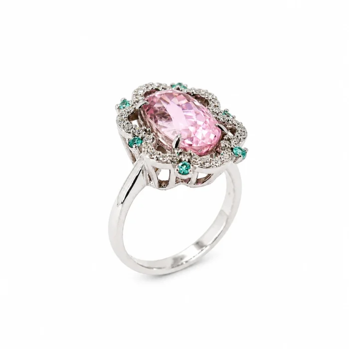 Ring with a large pink faceted center stone surrounded by a halo of small diamonds and green accents, set in silver metal.